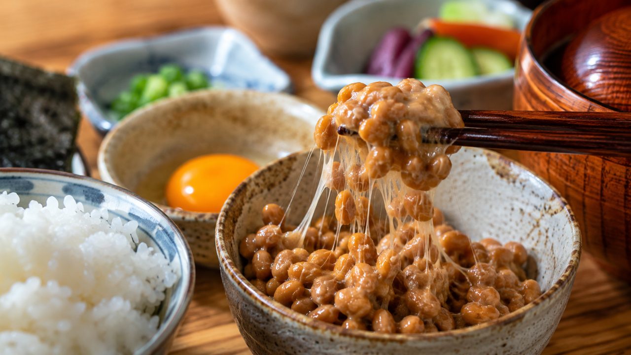 Bát natto đậu nành lên men Nhật Bản với đôi đũa nhấc sợi nhớt